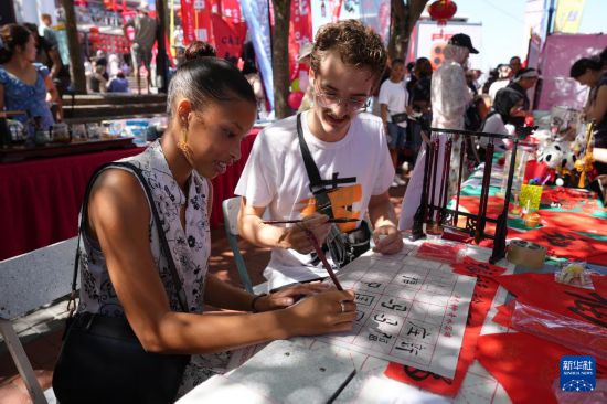 2月1日,人们在南非开普敦维多利亚港区举行的中国年庆祝活动上体验中国书法。新华社记者 王雷 摄